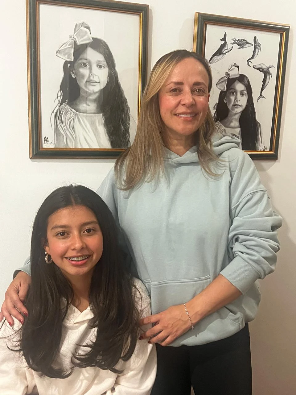 Juanita De La Hoz junto al retrato a grafito de su hija
